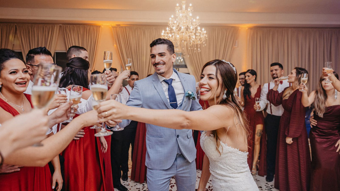 A bride and groom raise glasses in a joyful toast with their guests at an elegant wedding reception