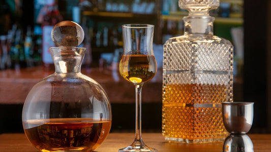 Crystal decanters and glassware arranged on a wooden home bar table