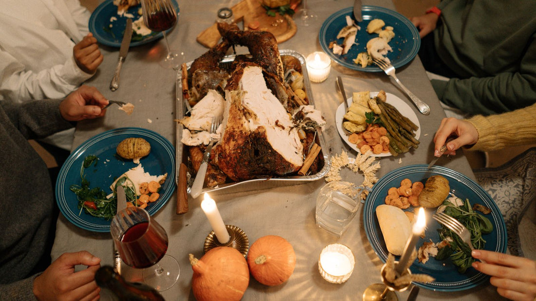 Top-down view of a Thanksgiving dinner table set with a roast turkey, side dishes and autumn decorations
