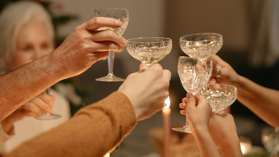 Family and friends raising crystal wine glasses in a toast at a festive holiday gathering