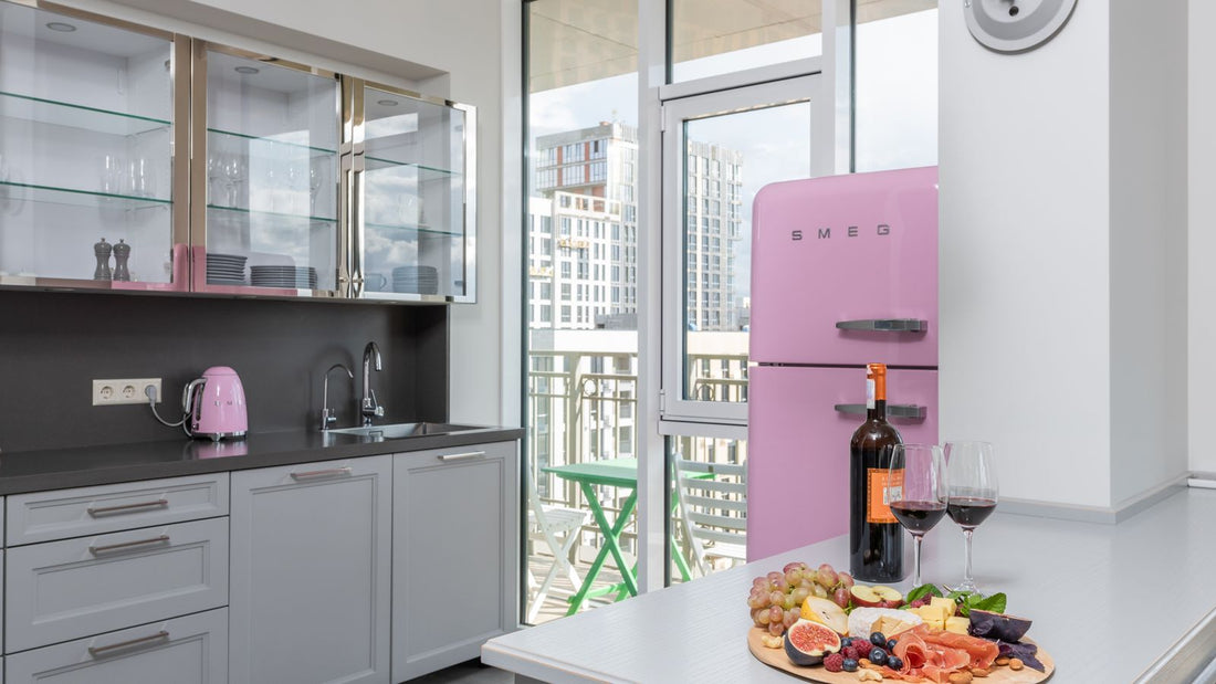 A bottle of red wine, two glasses and a fruit platter on the table of a bright new kitchen
