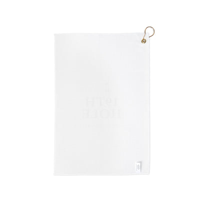 The 19th Hole golf towel shown folded with its gold grommet and ring for clipping to a golf bag