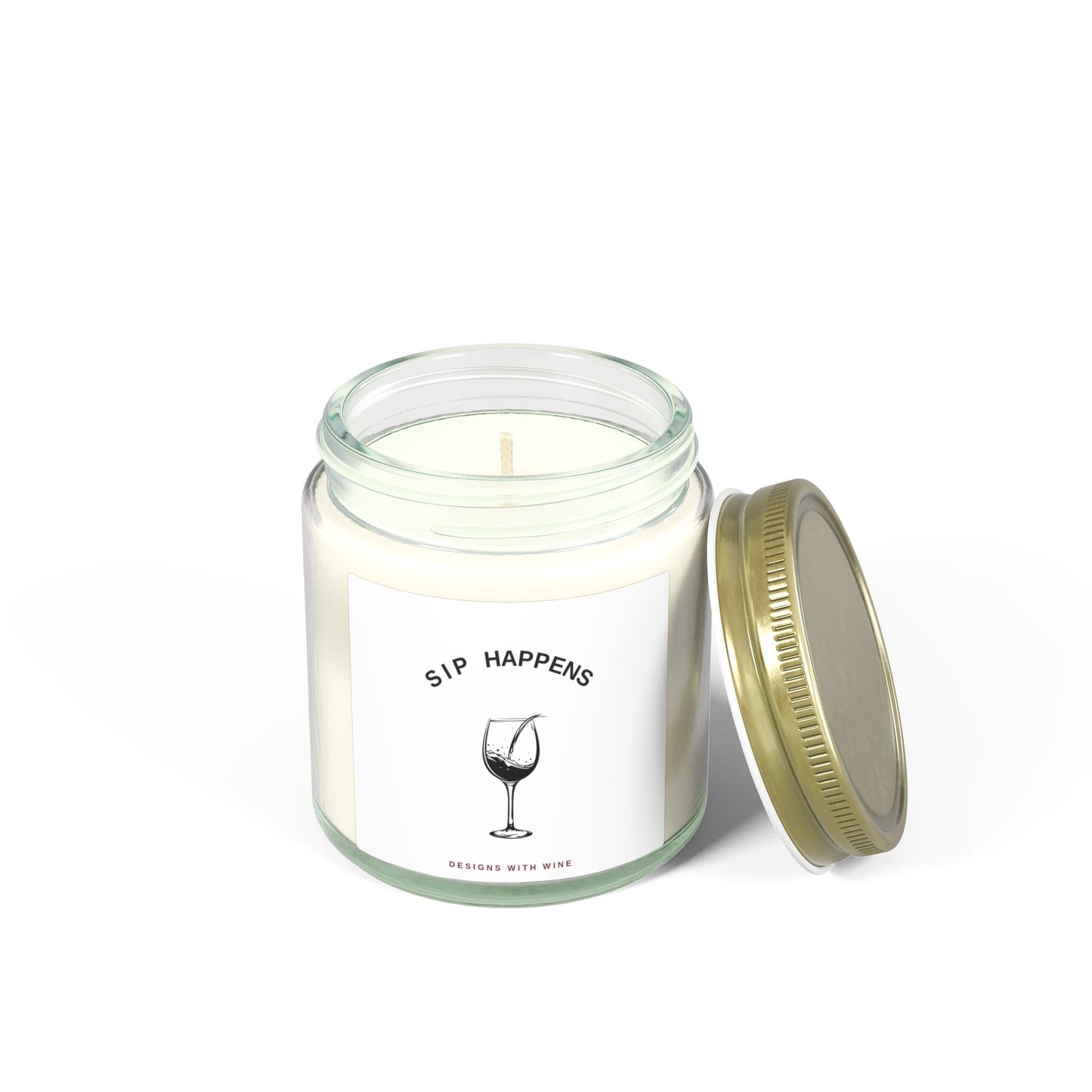 Sip Happens candle burning with the gold lid resting against the jar, white background
