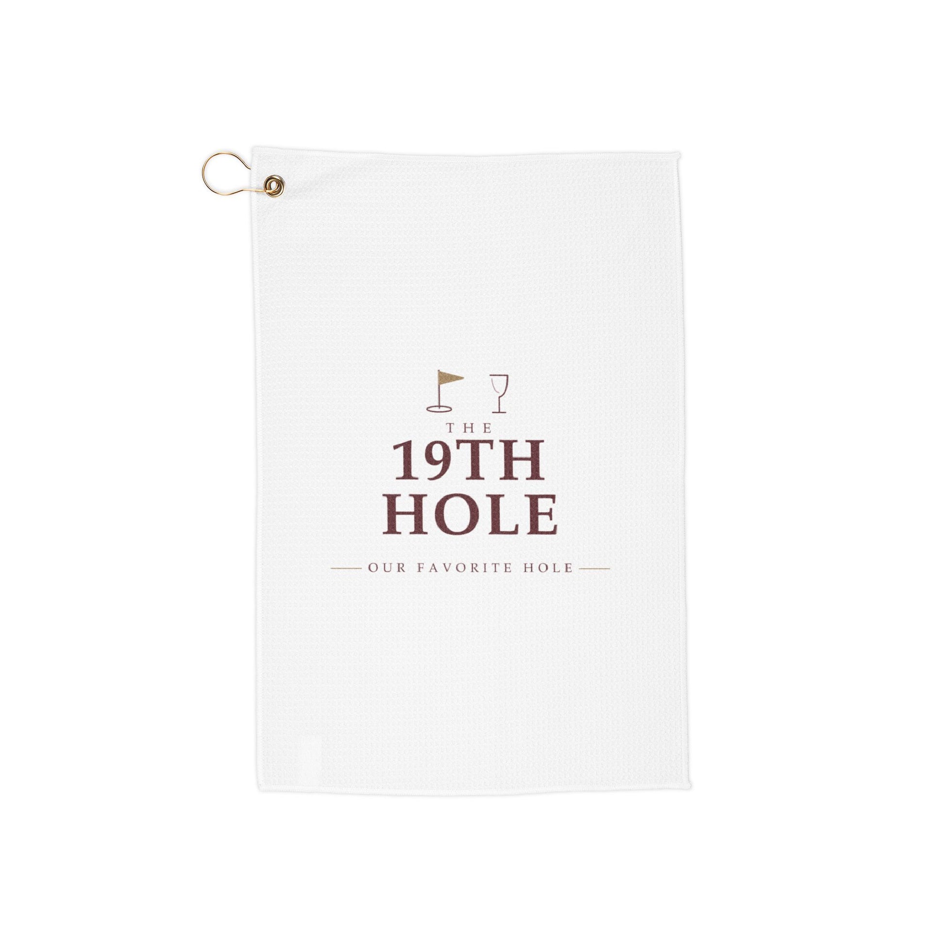 The 19th Hole golf towel by Designs With Wine, wine-red serif type with a gold flagstick and wine glass on white microfiber