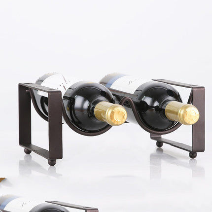Wrought iron stackable wine rack holding bottles in tiered display
